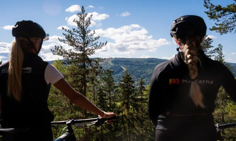 Två kvinnliga cyklister betraktar utsikten från Remsleberget.