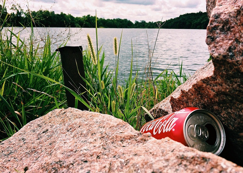 En bortkastad cola burk vid en sjö