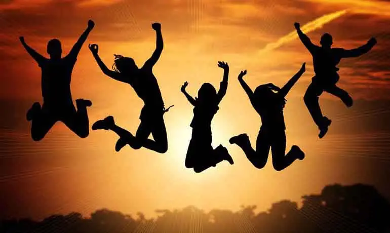 Fem unga som hoppar i luften