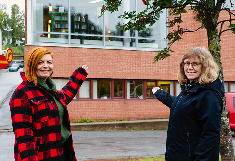 Elin Molin och Marianne Byström peka mot Sollefteå bibliotek 
