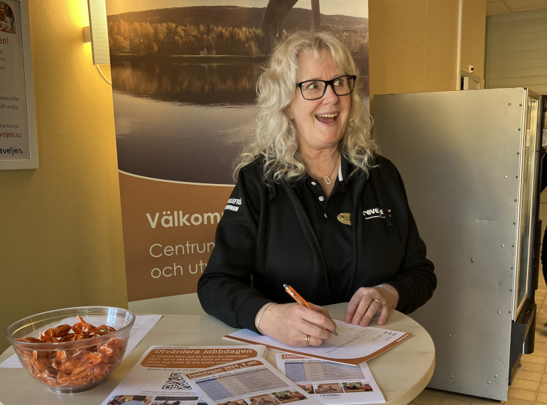 Glad kvinna står vid bord