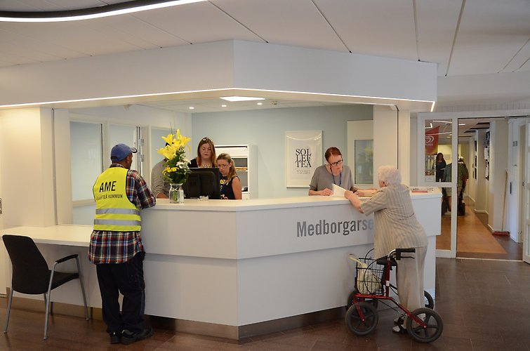 Två personal från medborgarservice en man och tre kvinnor prata med en äldre dam och annan man i receptionen i kommunhuset i Sollefteå.